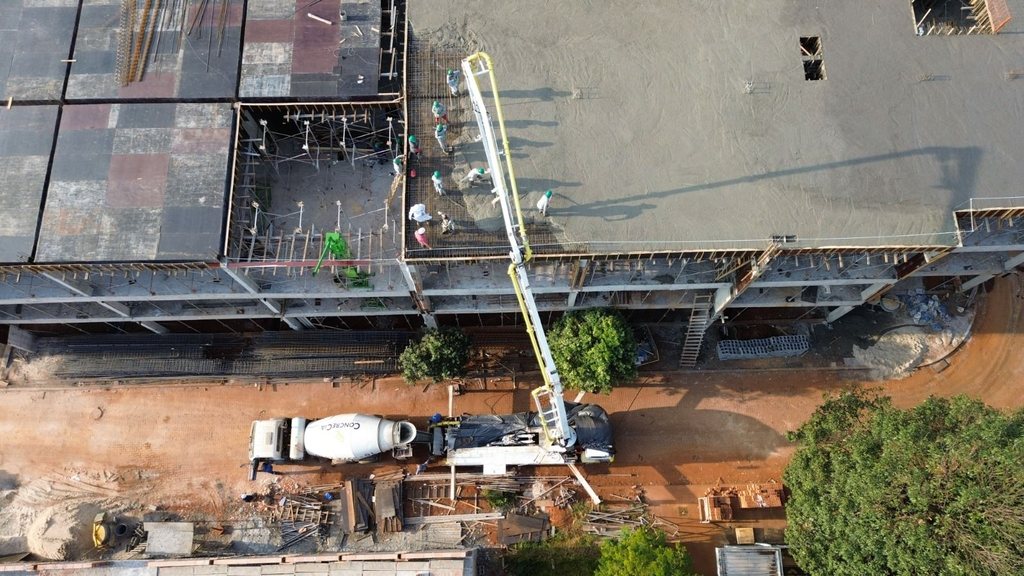 Vista aérea de bomba-lança CONCRECIA bombeando concreto em laje, com caminhão betoneira no canteiro em Ribeirão Preto
